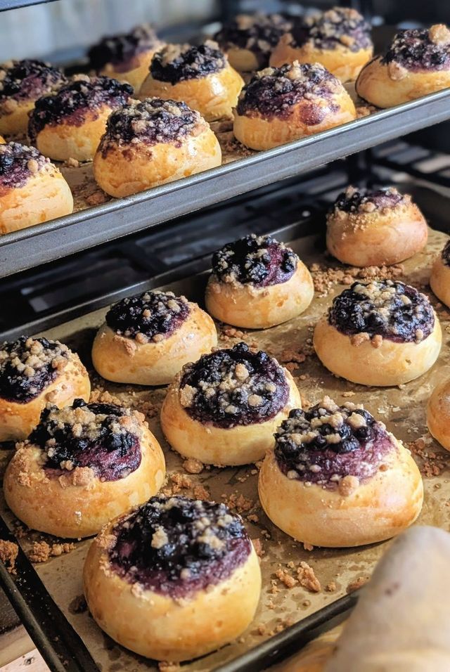 Round buns with a berry and crumb topping on a tray