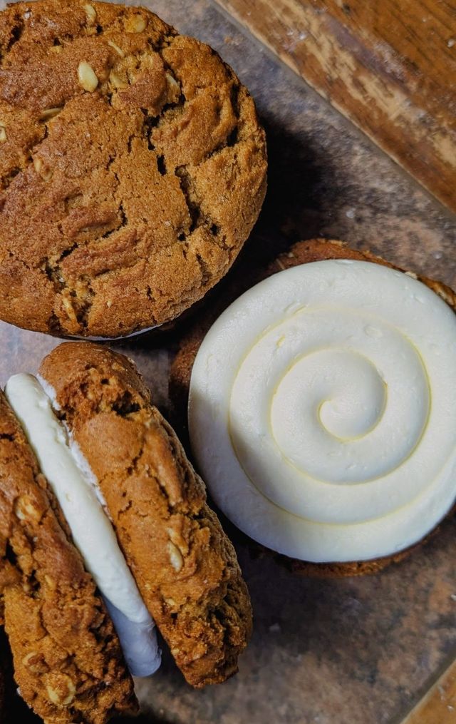 Thick cookies filled with buttercream beside a round swirl of buttercream