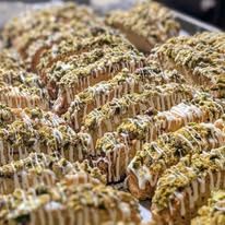 Rows of drizzled bars sprinkled with green nut crumbs