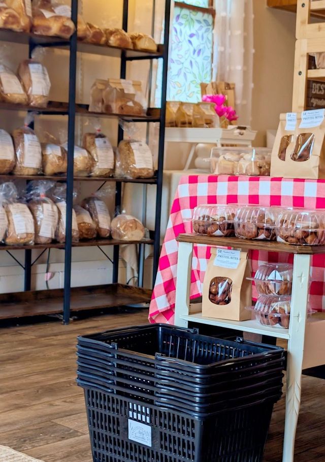 Shopping baskets stacked by the bread shelves and the gingham table in our shop