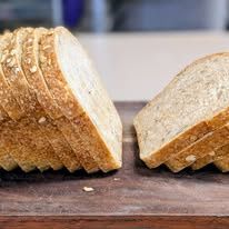 A sliced loaf on a wooden board, showing its soft crumb