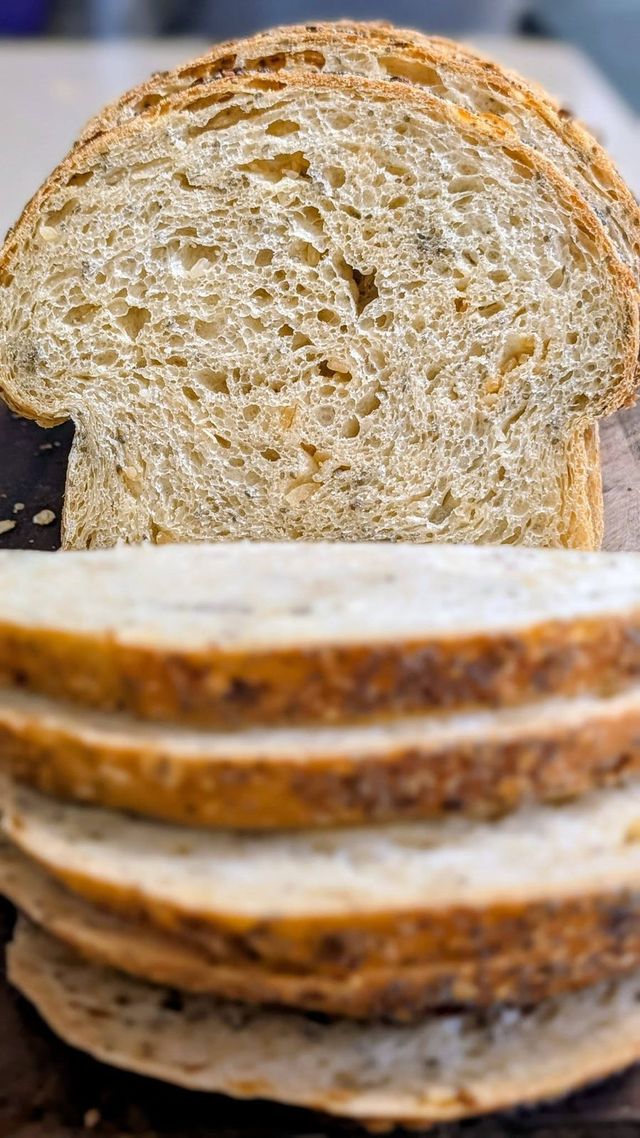 A sliced loaf standing on end, showing a soft, speckled crumb