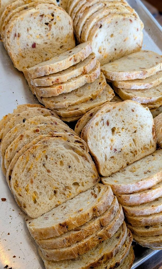 Stacks of sliced bread with flecks baked into the crumb